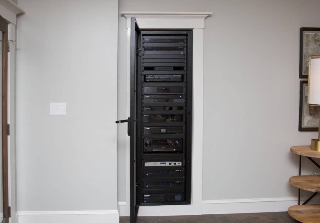 Tall in-wall AV rack with multiple audio-video components.